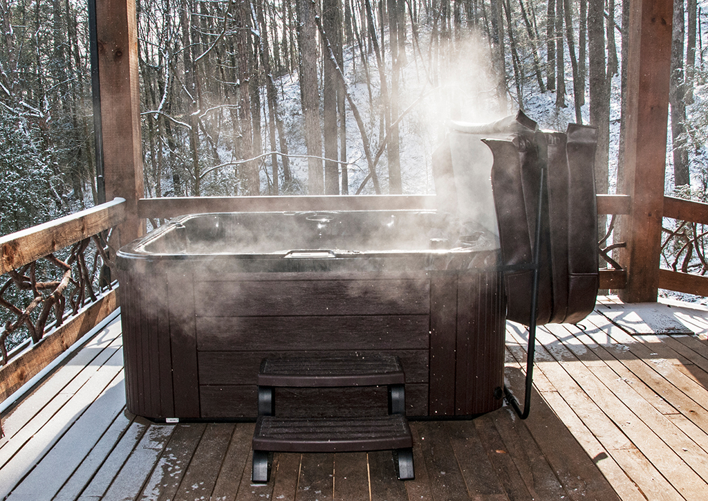 Steaming hot tub on deck with snow in background